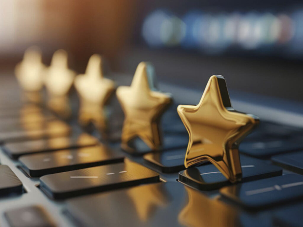 Golden five-star rating symbols lined up on a dark laptop keyboard.
